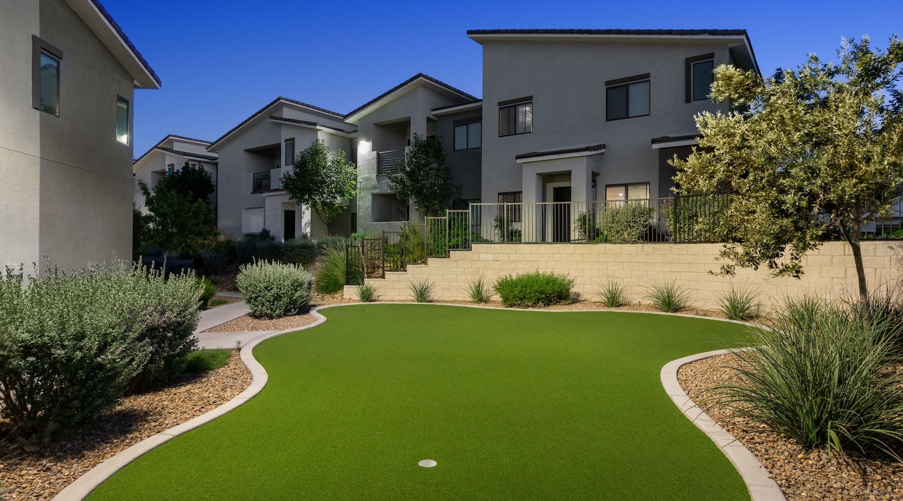 putting green area with apartment building in the background